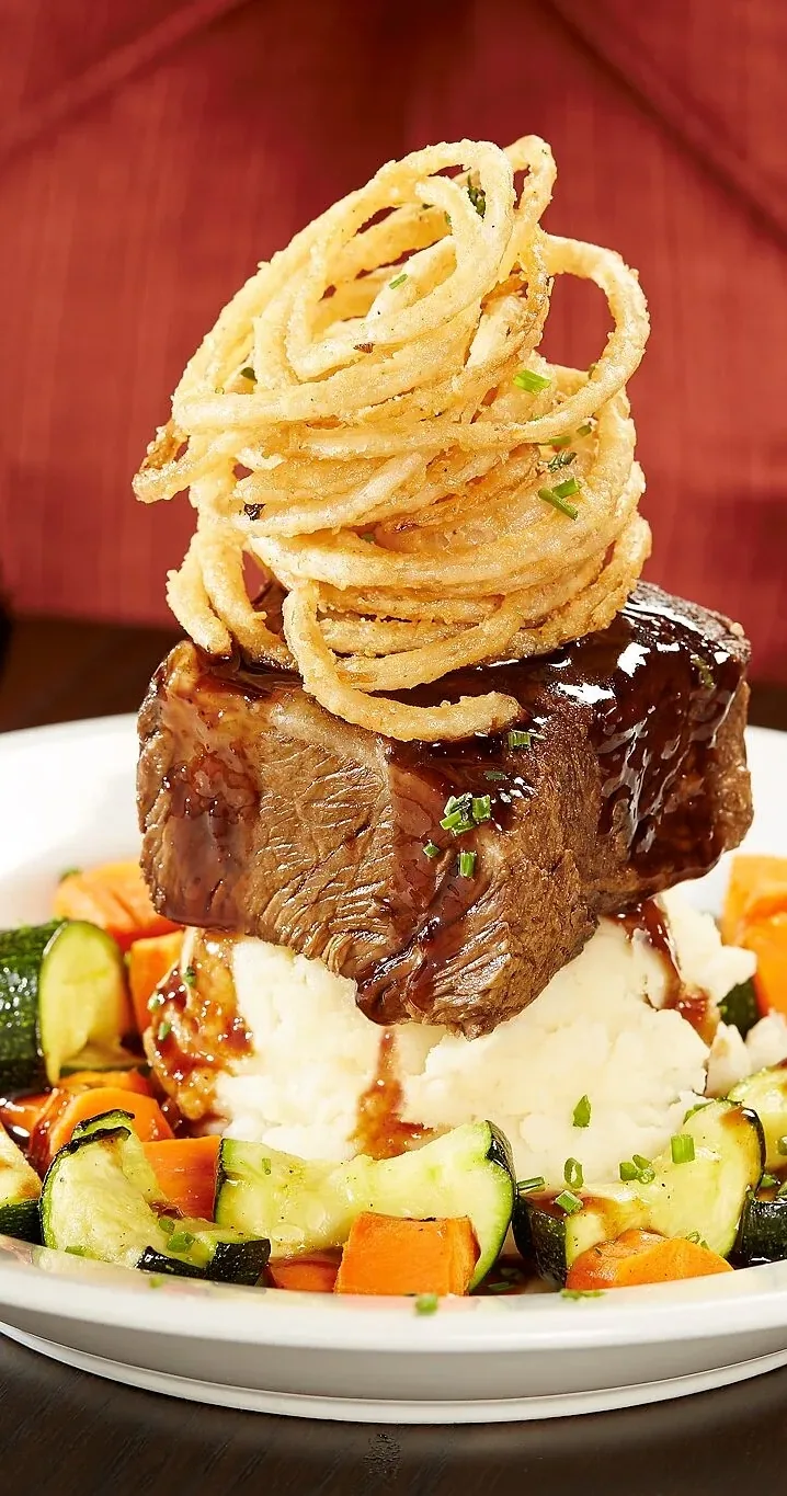 A grilled ribeye steak with a loaded baked potato and grilled asparagus